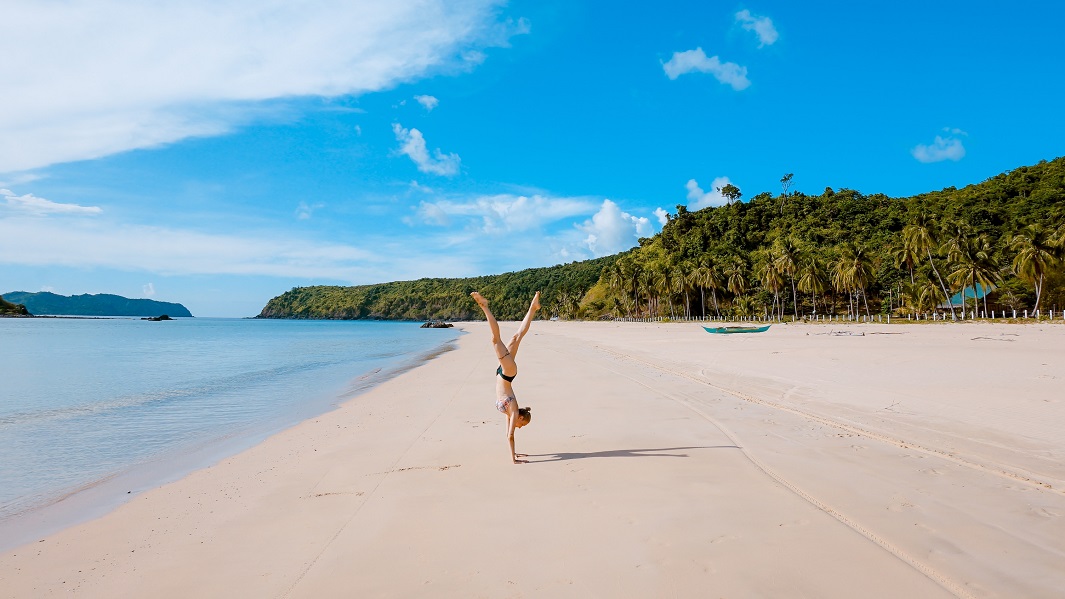 woman-doing-a-handstand-on-the-beach